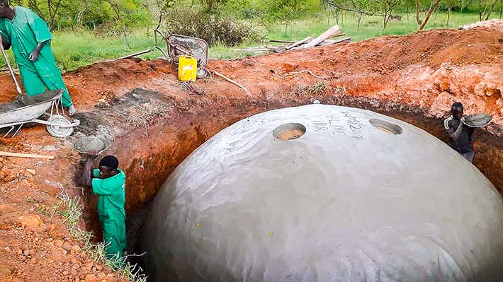 Men building under ground water storage tank for clean water in Uganda.