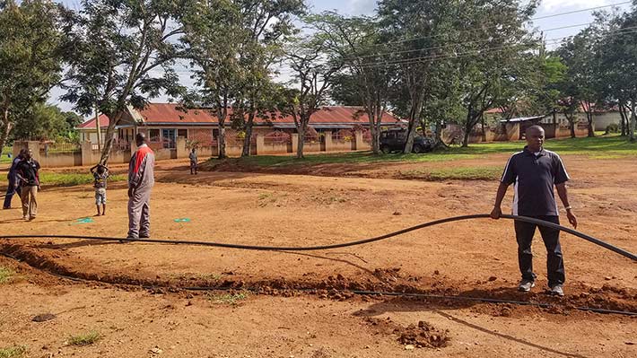 Men laying water pipes under ground for clean water in Uganda.